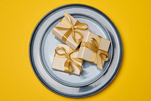 Gift boxes with gold bows on a white plate with a gold rim. A fe, a Food & Drink Photo by ndanko