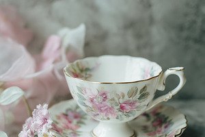 Porcelain tea set with pink floral pattern, gold details, and sm, a Photo by Studio ANNA