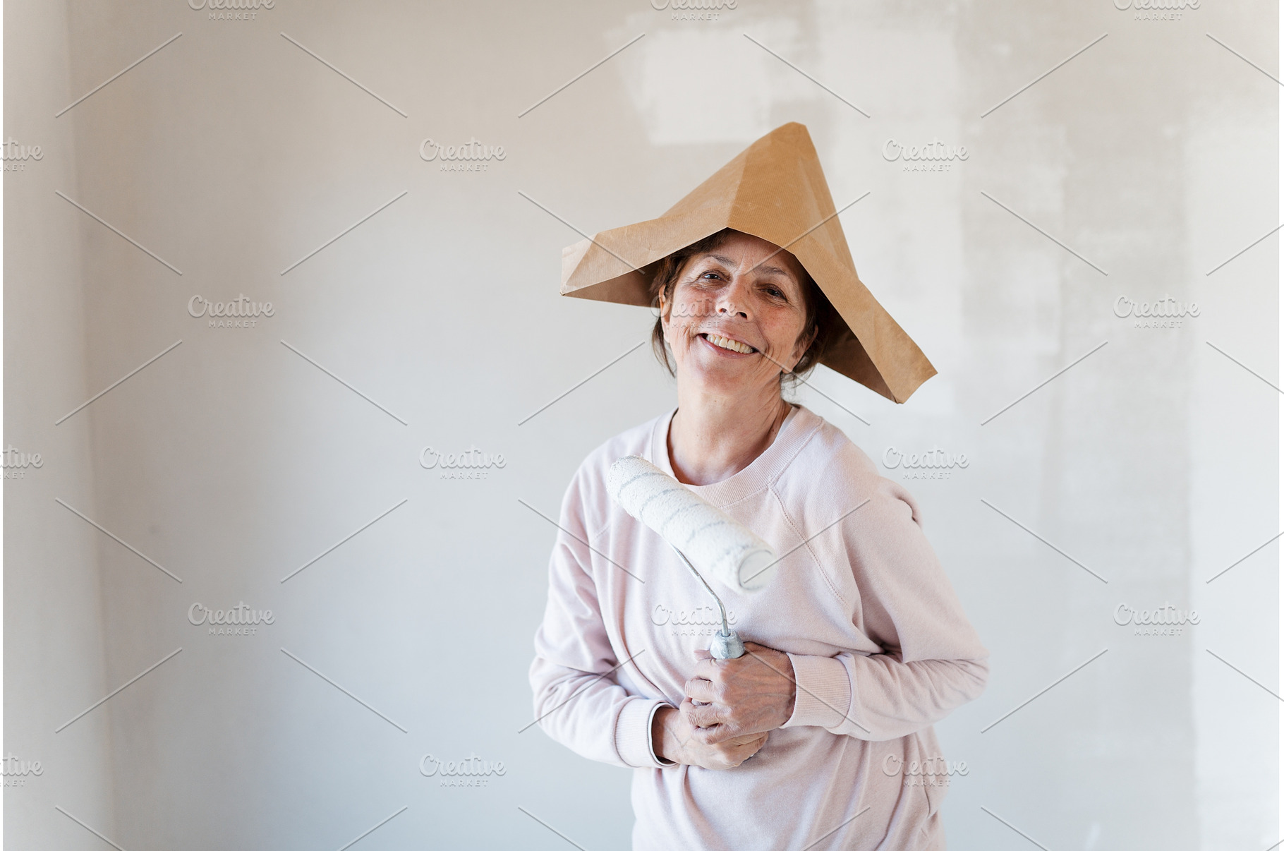 Senior woman painting walls with, a Person Photo by HalfPoint