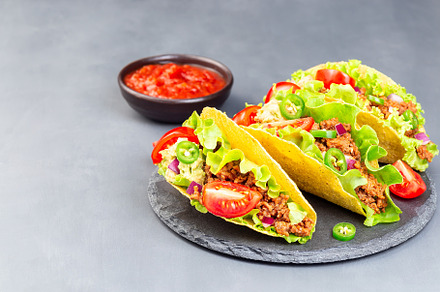 Taco shells on stone plate with let containing taco, shell, and lettuce, a Food & Drink Photo by iuliia_n