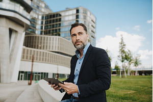 Mature businessman sitting in park, a Person Photo by HalfPoint