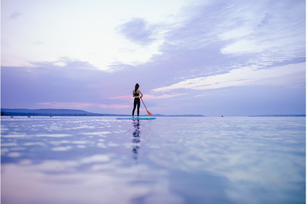 Young beautiful girl surfer paddling, a Person Photo by HalfPoint