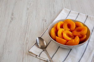Healthy Organic Canned Peach Halves in a Bowl, side view. Copy s, a Food & Drink Photo by LiudmylaChuhunova