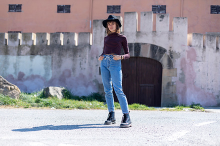 Woman with hat standing, hands on pocket in somewhere the city while looking at, a Person Photo by 2Design