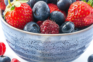 Colorful mixed berries in a speckled, a Photo by LOGOCREATIVE
