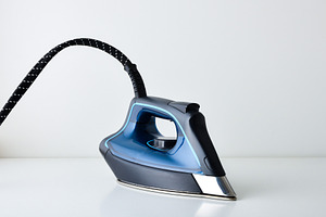 Blue steam iron resting on white table and isolated background, a Technology Photo by Davizro's Market