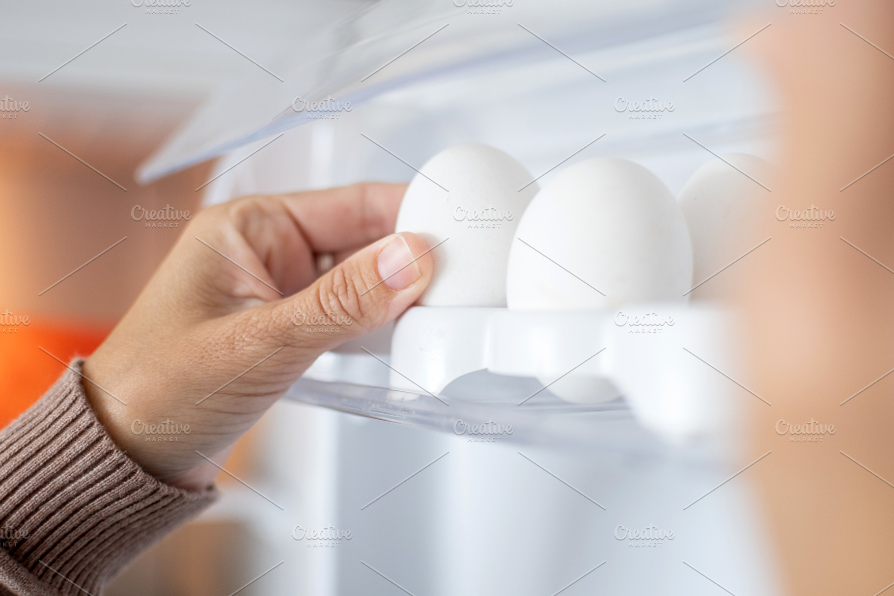 Hand taking fresh eggs from refrigerator door shelf, a Food & Drink Photo by etorres69