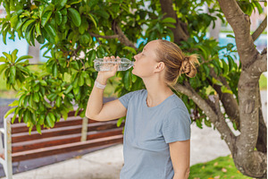 A woman drinking water in a sunny, a Nature Photo by Elizaveta Galitskaya