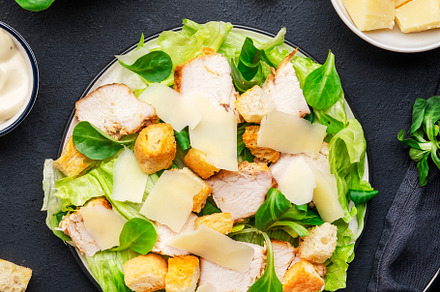 Classic Caesar salad with chicken, iceberg salad, croutons, parm, a Food & Drink Photo by 5PH