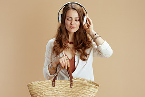 relaxed elegant woman in blouse and shorts on beige, a Person Photo by Alliance Images