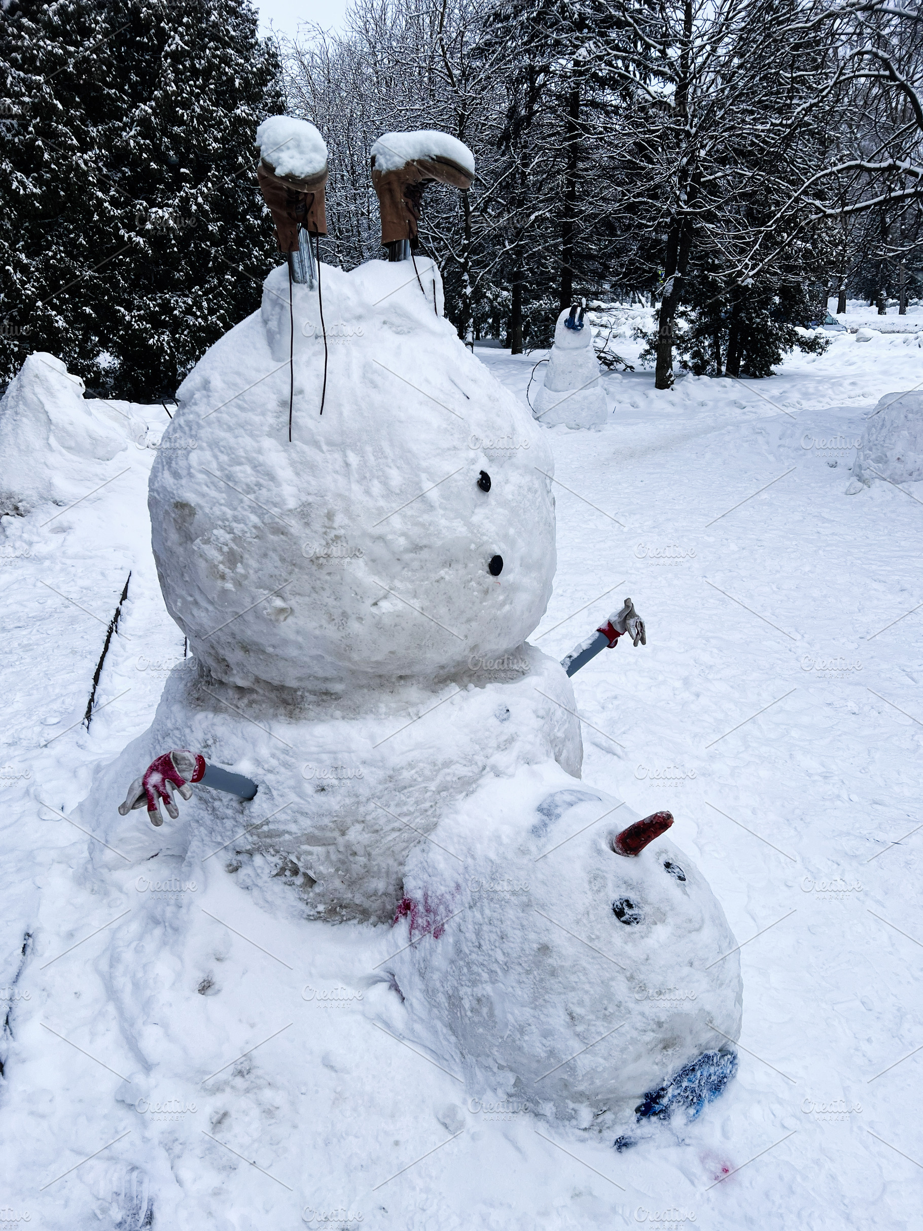 Playful snowman duo in a snowy park with carrot nose and twig arms, a Photo by AS photostudio