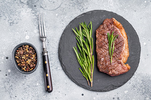 Close up of a flavorful grilled striploin or strip steak, garnis, a Food & Drink Photo by composter-box@mail.ru