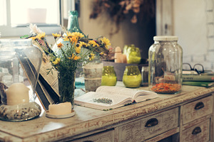 Jars with plant infusions featuring chamomile, honey, and lemon