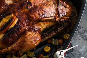 Roast duck and oranges on a black slate board, close view