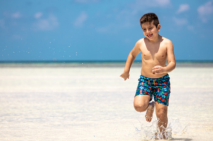 Little kid running on a white sand beach, a Person Photo by Cosca