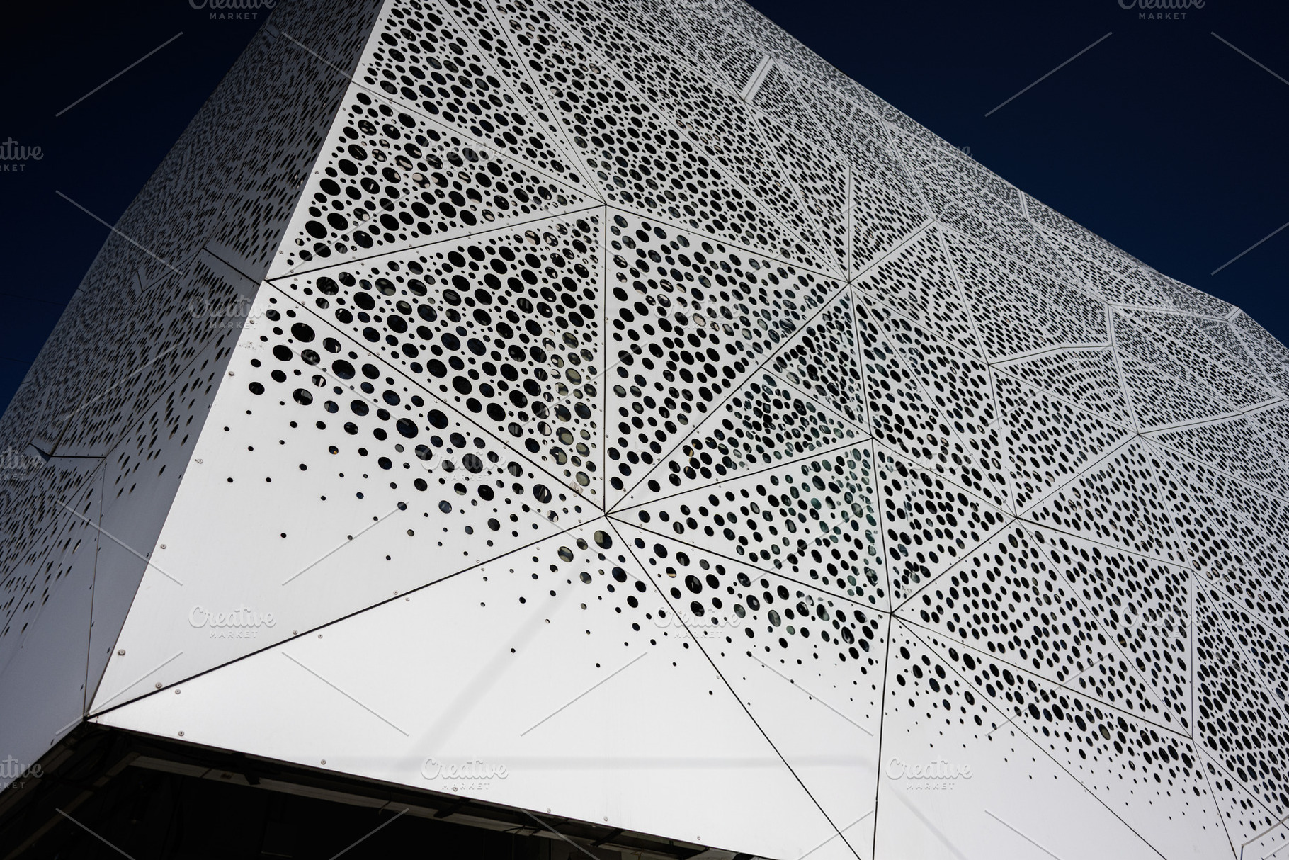 Modern architectural structure with geometric patterns and perforated metal pan, a Photo by AS photostudio