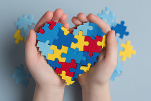Childrens hands holding puzzle heart, a Photo by Pixeness Studio