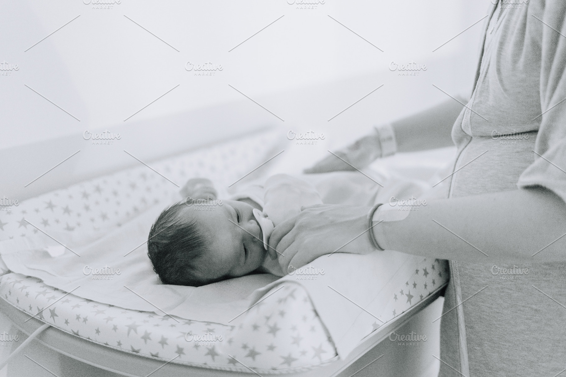 The hands of a mother changing her newborn in the hospital, a Person Photo by rubenchase