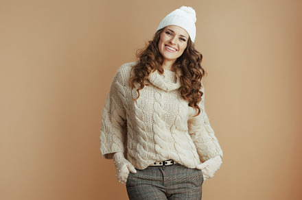 Portrait of smiling woman in beige sweater, mittens and hat, a Person Photo by Alliance Images