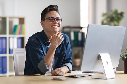 Inspiration Concept. Smiling Young Businessman Sitting At Workplace And Looking, a Photo by Prostock-Studio
