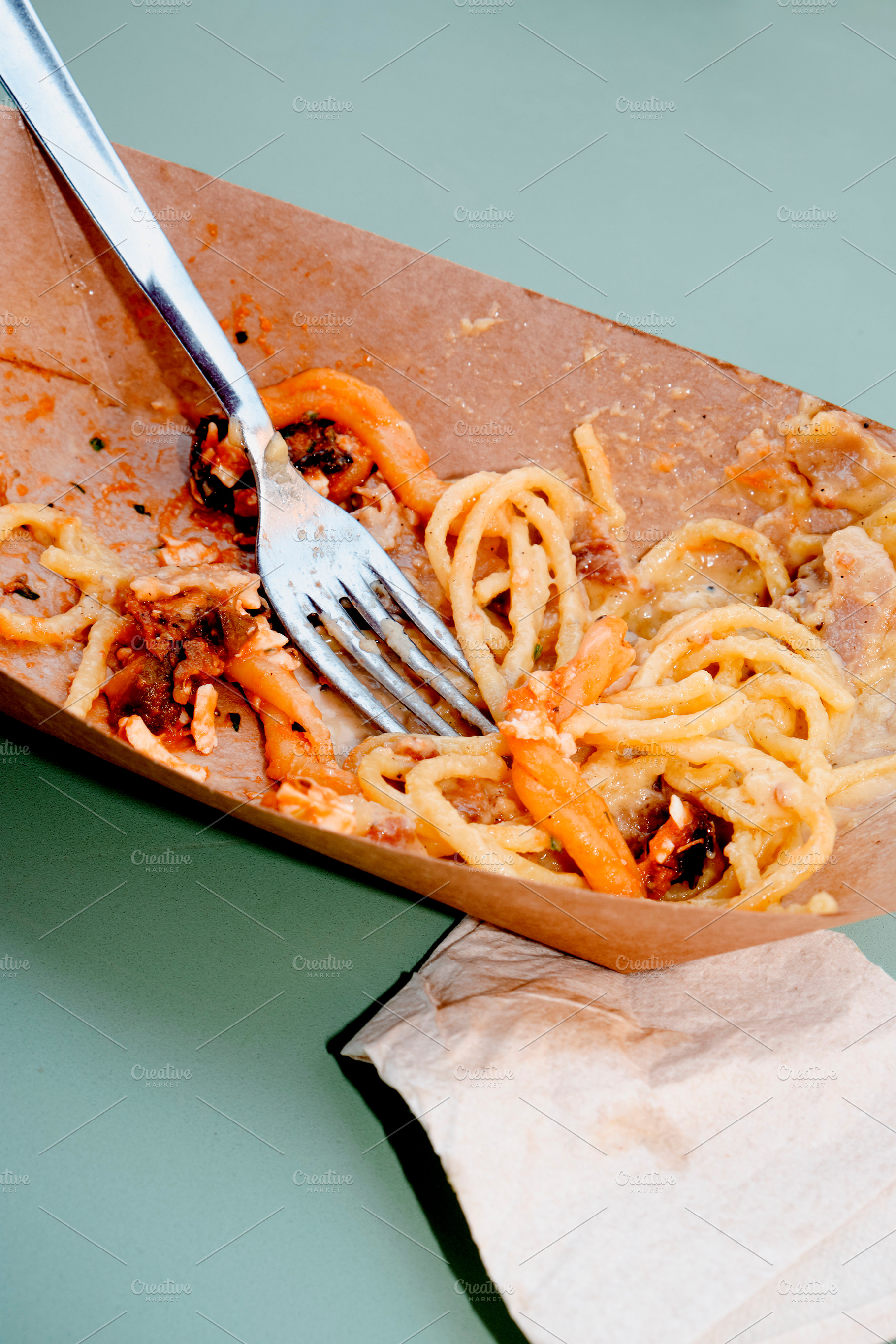 leftovers of two pasta dishes on a green table, a Photo by Nito