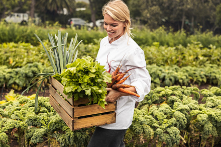 Smiling young chef carrying fresh vegetables on a farm, a Person Photo by Jacob Lund