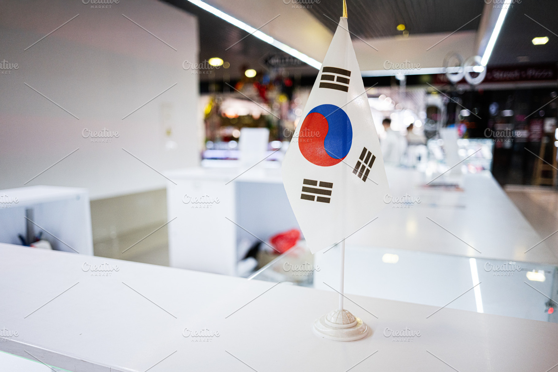 South Korean flag displayed on a table inside a bright modern interior, a Photo by AS photostudio