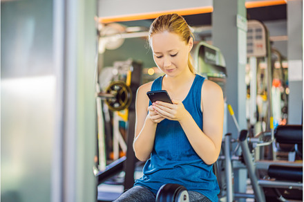 Young woman using phone while, a Sports & Recreation Photo by Elizaveta Galitskaya