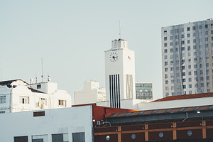 White clock tower in city skyline, an Architecture Photo by SkyNext
