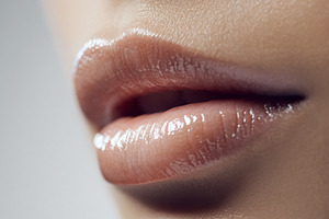 Close up of a female applying lip gloss on plump, glossy lips, s, a Beauty & Fashion Photo by Studio ANNA