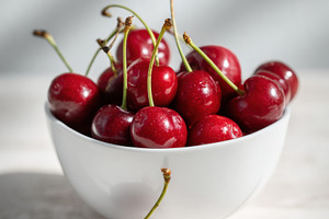 White bowl with cherries on table, a Food & Drink Photo by Virgo Studio