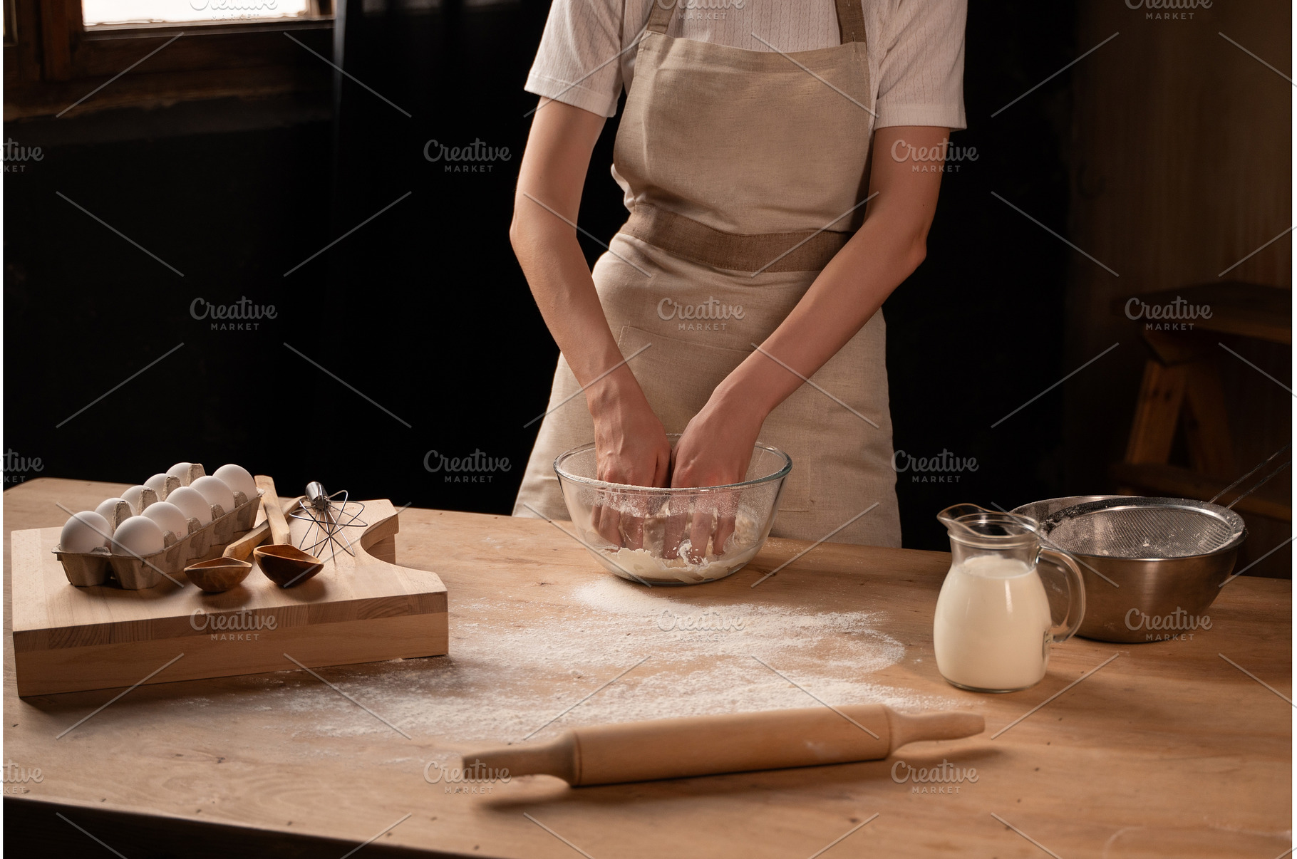 Baker kneading dough in glass bowl, a Food & Drink Photo by volodymyrshtun13795
