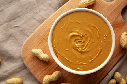Organic Peanut Butter in a Bowl, top view. Flat lay, overhead.