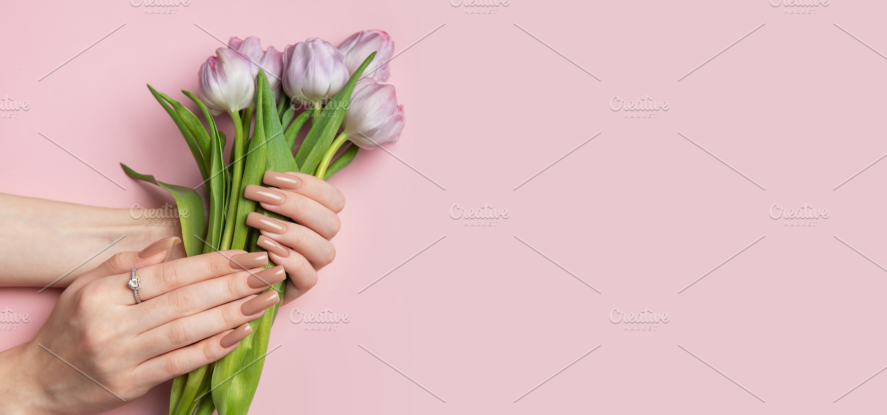Woman holding bouquet of purple tulips showing manicure on pink, a Beauty & Fashion Photo by Olena Rudo