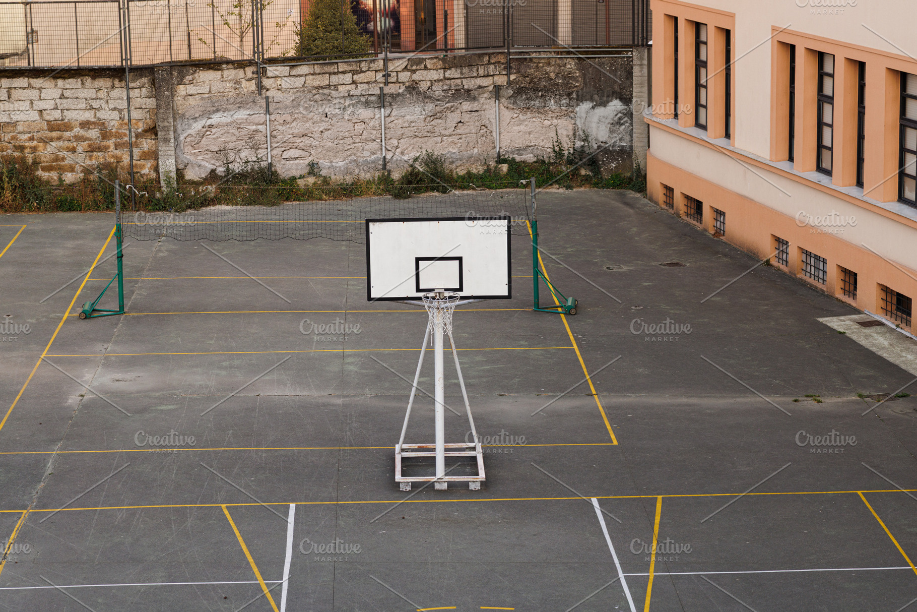 Empty outdoor basketball court with a net and building in the ba, an Architecture Photo by Bepslabor