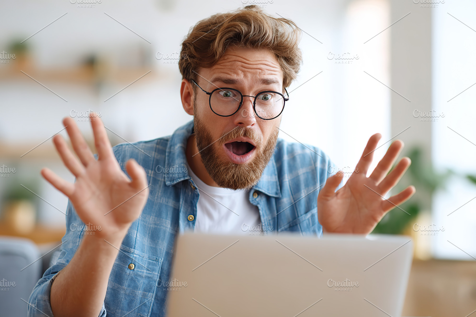 Man in blue shirt reacts in surprise while using laptop at home during daytime, a Person Photo by AlyaAnd