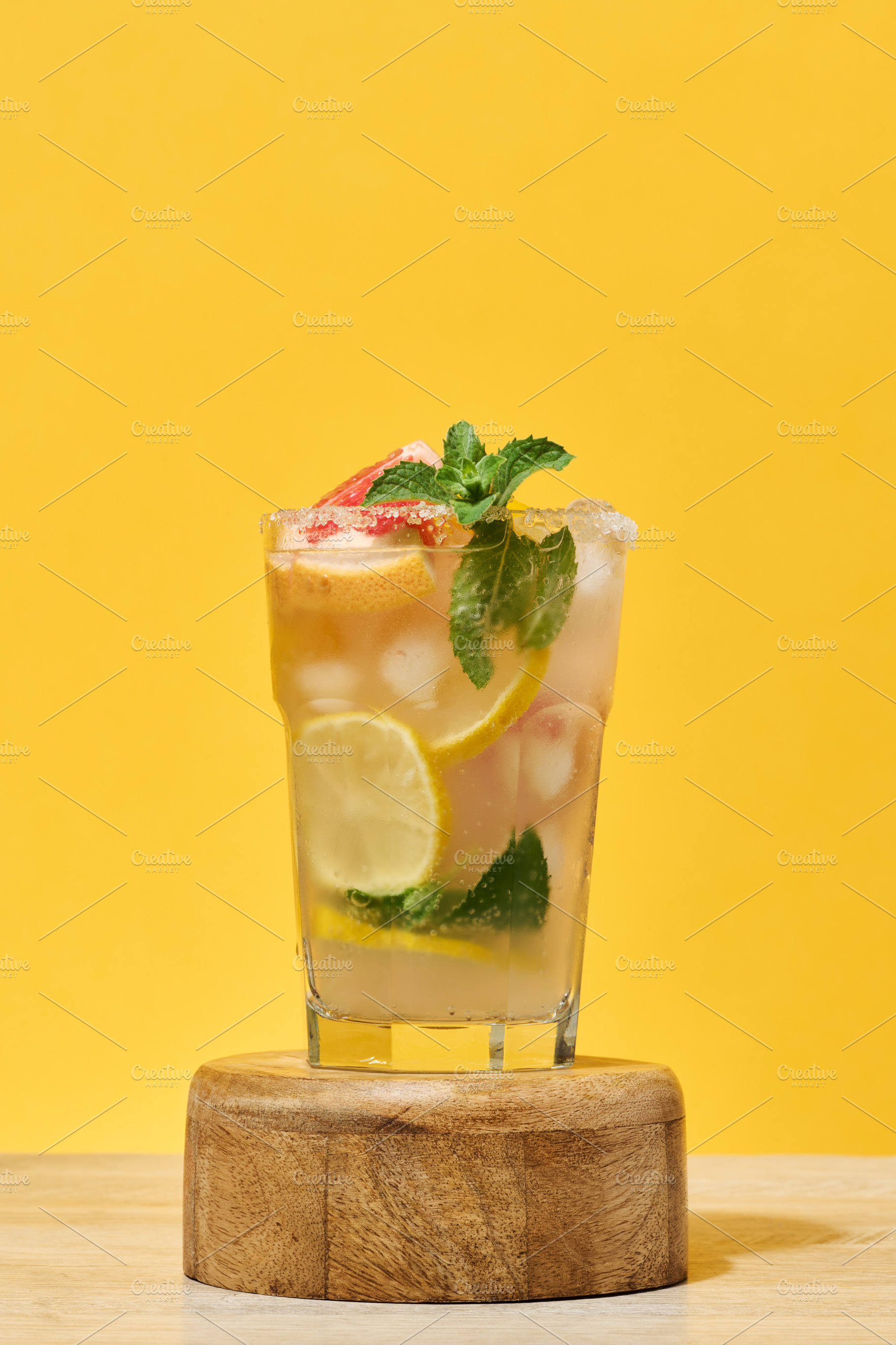 Glass with a cold drink, grapefruit slices, ice, mint and lemon, a Food & Drink Photo by ndanko
