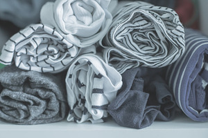 Marie Kondo tyding up method concept - folded clothes. White, gray, blue and st