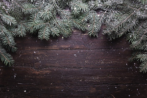 Christmas and New Year decoration composition. Top view of fur-tree branches on wooden background with place for your text