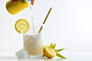 Refreshing lemon drink with ice on a white isolated background, a Food & Drink Photo by Davizro's Market