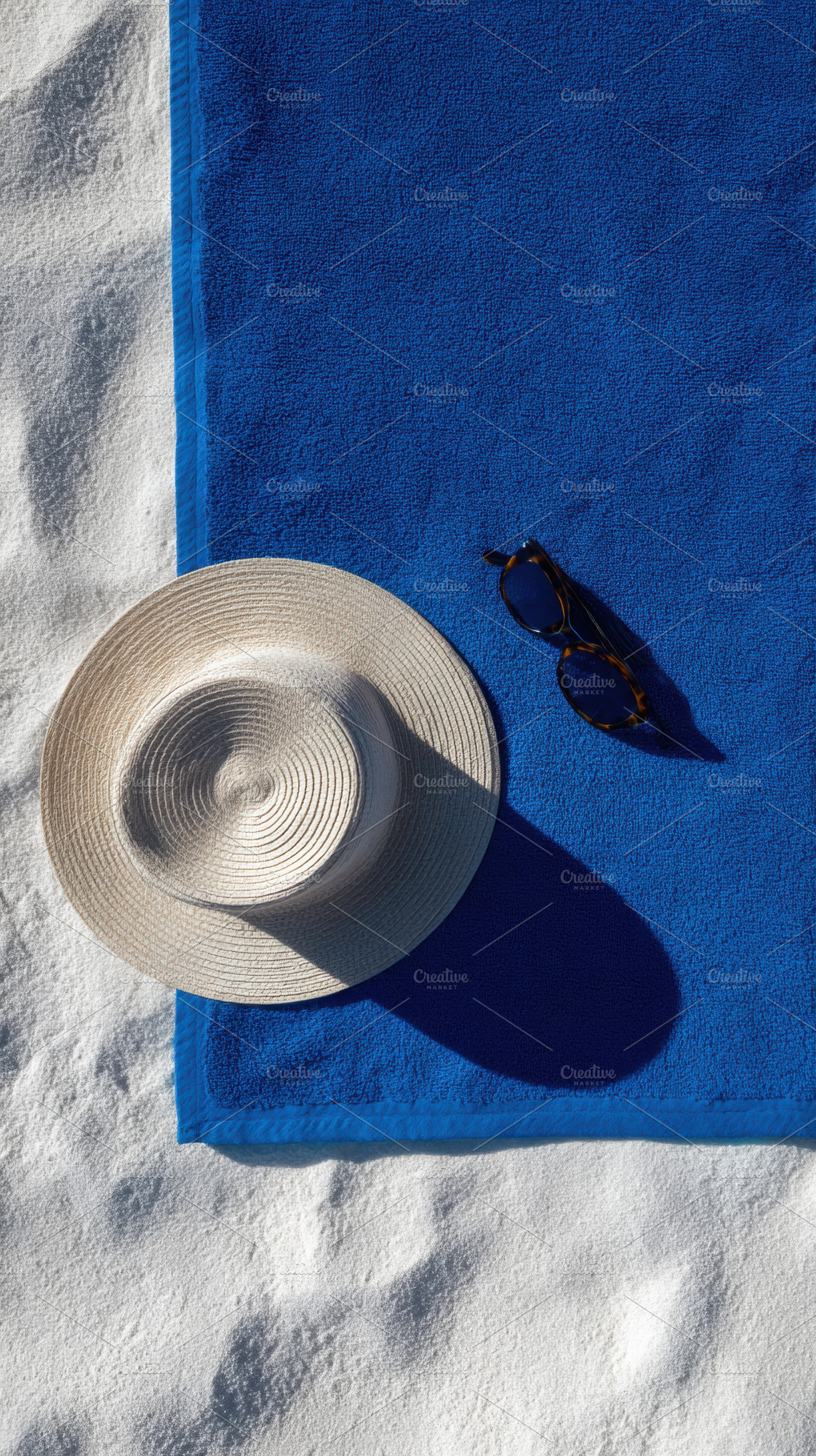 Blue beach towel with sunglasses, a Photo by Virgo Studio