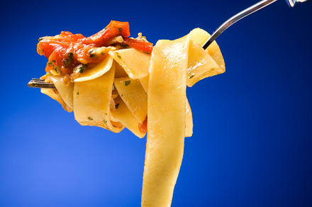 Tagliatelle with clams on a red background
