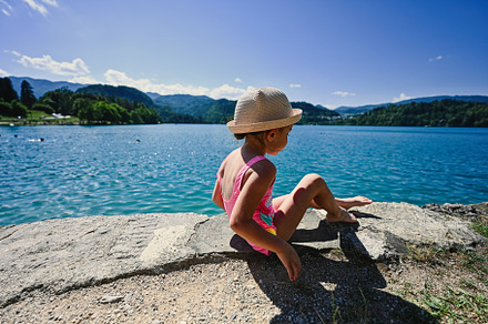 Back of baby girl is swimsuit and hat sit in pier of view beauti, a Photo by AS photostudio