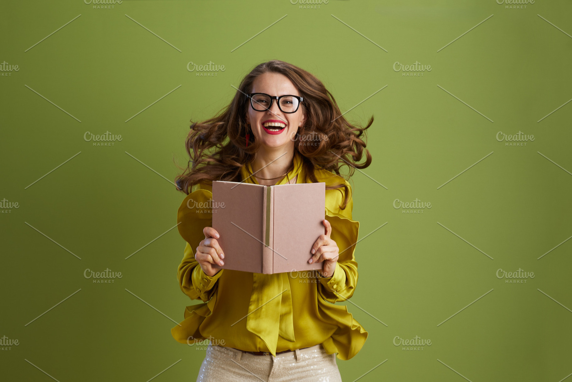 smiling healthy woman in green blouse and glasses on green, a Person Photo by Alliance Images
