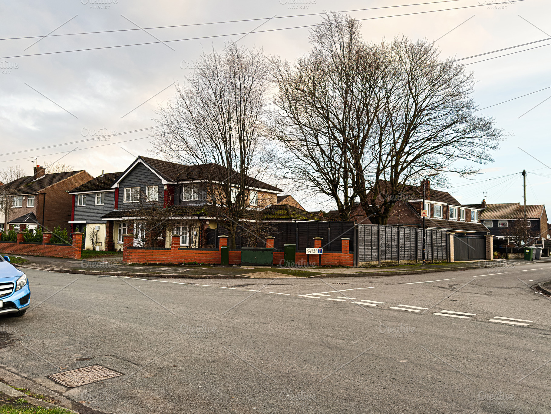 Family home Orkney Drive street in Manchester with trees and a parked car on a, a Photo by AS photostudio