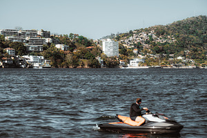 Jet ski on bay near hillside city, an Architecture Photo by SkyNext