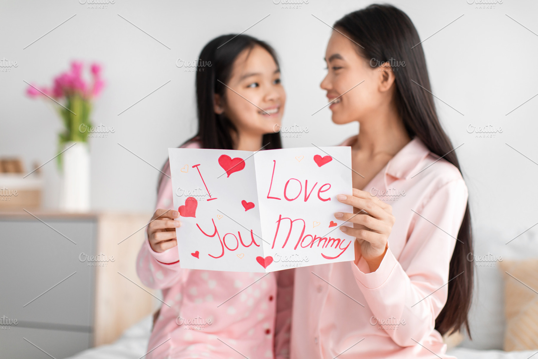 Satisfied happy korean young girl and millennial female read card and congratul, a Photo by Prostock-Studio