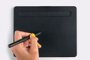 Close-up of a hand holding a stylus on a black digital graphic t, a Technology Photo by Ales Munt