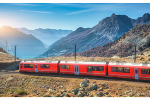 Red modern train is winding through, a Transportation Photo by den-belitsky