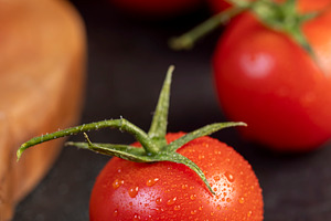 several red round cherry tomatoes on the table with small green tails, a Photo by rsoollAI